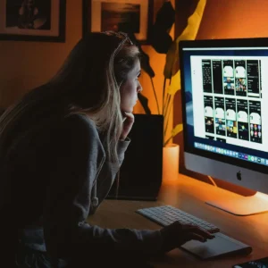Emprendedora trabajando frente a una computadora en un entorno oscuro para practicar un ayuno de dopamina y mejorar su enfoque.