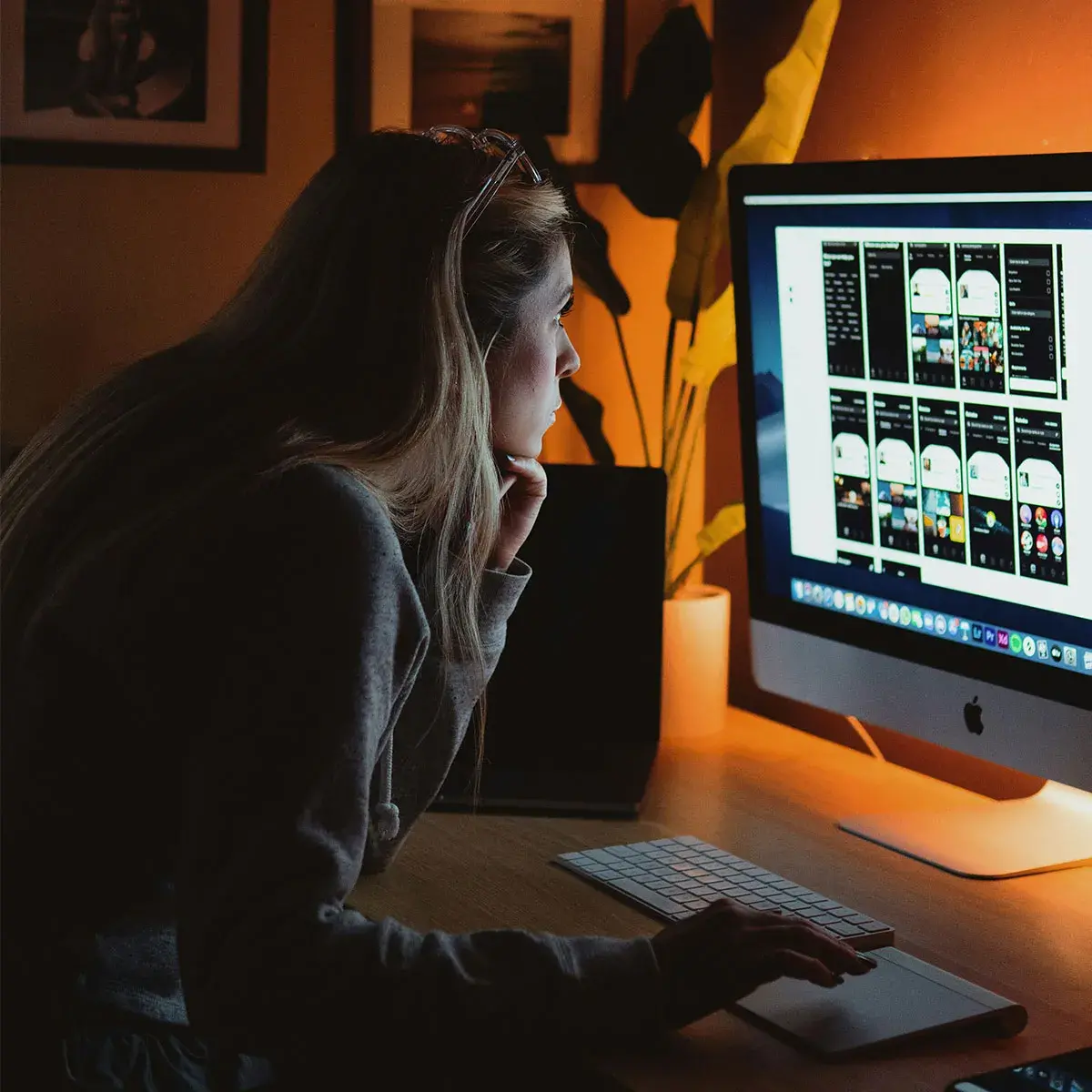 Emprendedora trabajando frente a una computadora en un entorno oscuro para practicar un ayuno de dopamina y mejorar su enfoque.