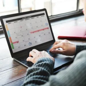 Emprendedora revisando su calendario en una laptop para aplicar la cronobiología aplicada al trabajo y optimizar su productividad.