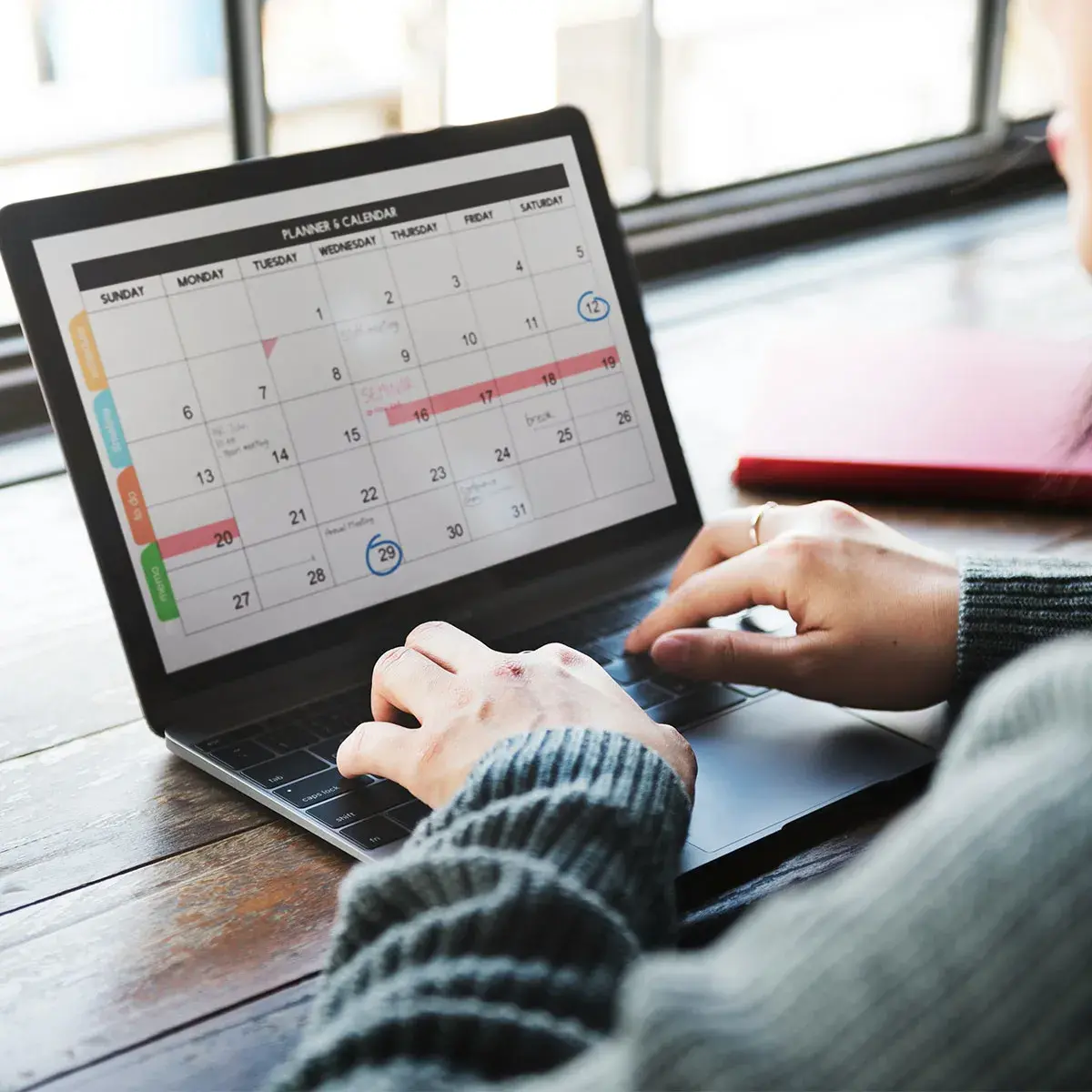 Emprendedora revisando su calendario en una laptop para aplicar la cronobiología aplicada al trabajo y optimizar su productividad.