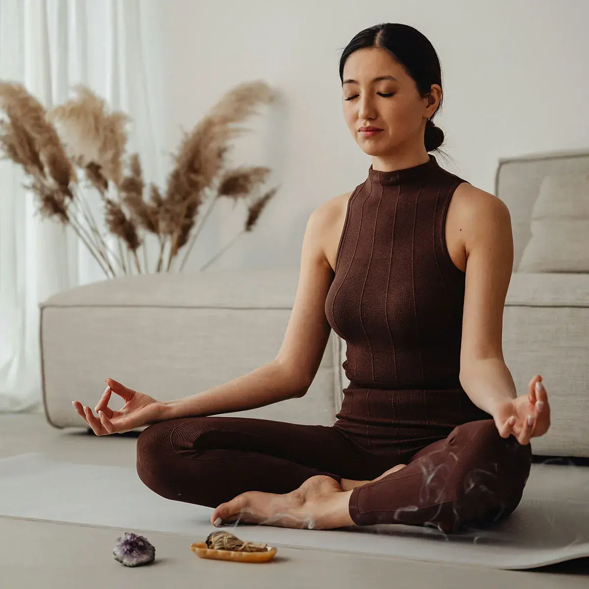 Mujer emprendedora en postura de meditación para optimizar energía y enfoque cerebral.